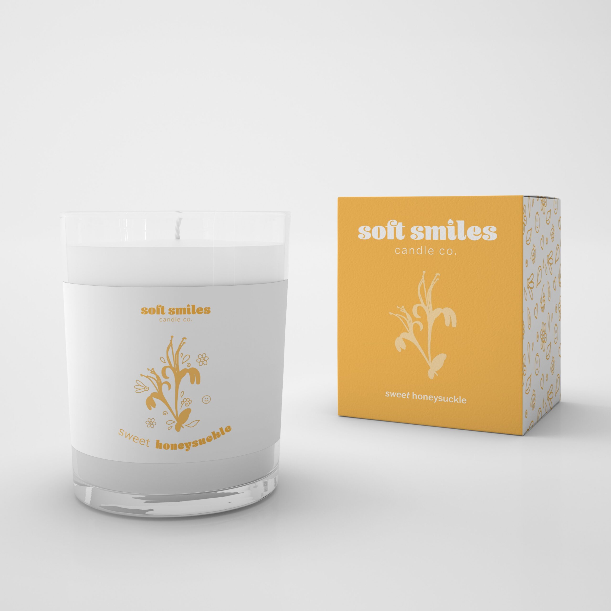 Mock up of a Soft Smiles brand candle and box packaging on a white background. The candle scent is sweet honeysuckle and the color palette is yellow and white